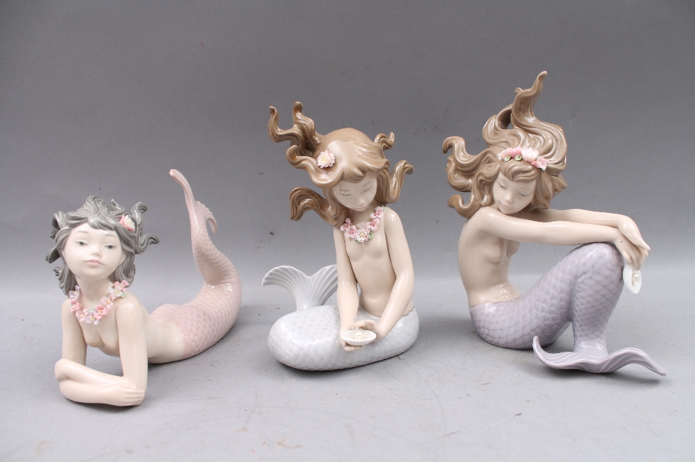 Three Lladro figures modelled as young mermaids, the tallest approx 16cm high.