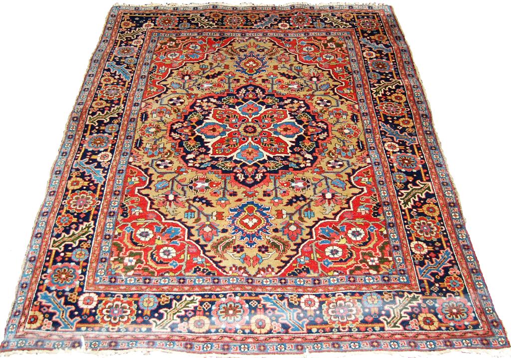 A Persian woollen Tabriz type carpet, having a central flower issuing further stylised scroll