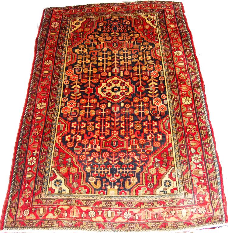 A Persian woollen rug, having a complex stylised floral field within multiple trailing borders,
