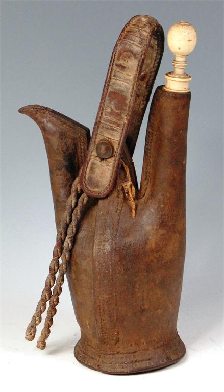 A 19th century North African hide water-jug, the swing handle decorated with embossed roundels,