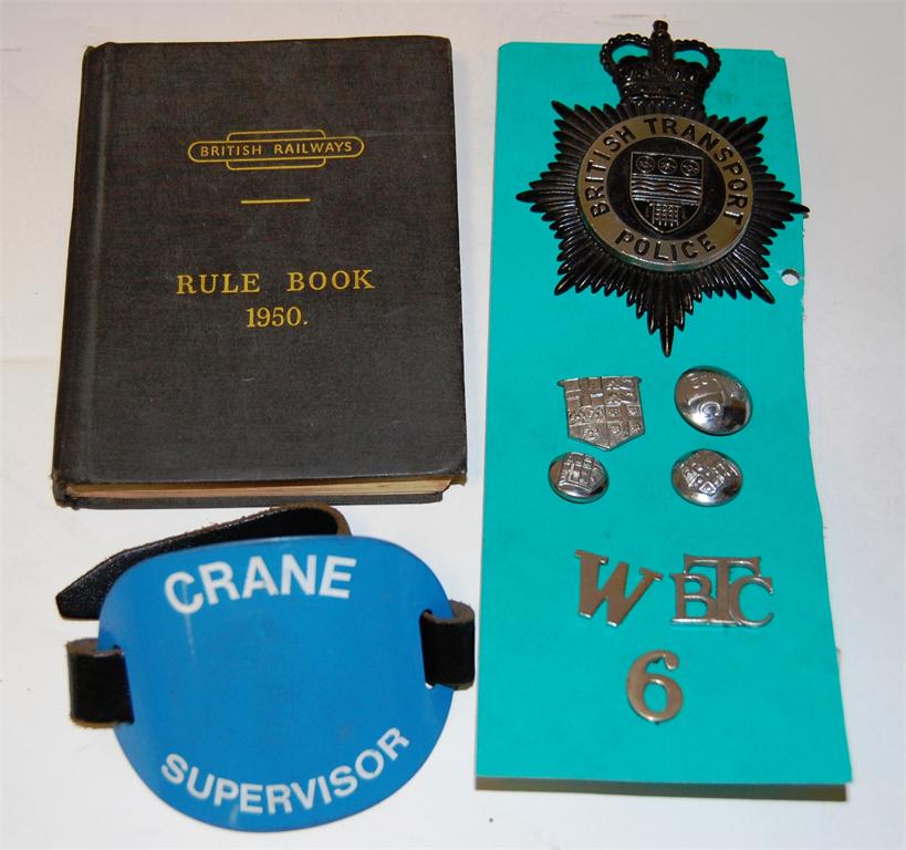 British Transport Police helmet plate, 3 buttons and uniform badges, a BR 1950 rule book and a Crane