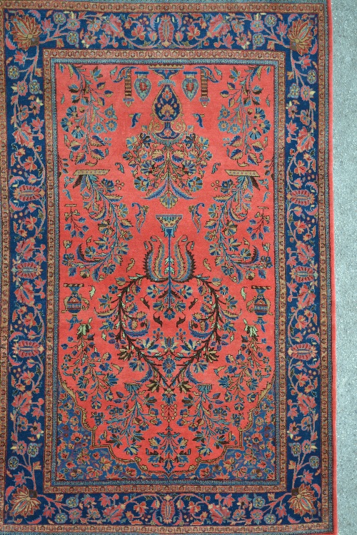 Saruq rug with vase and floral design on rose ground with borders, 77ins x 49ins