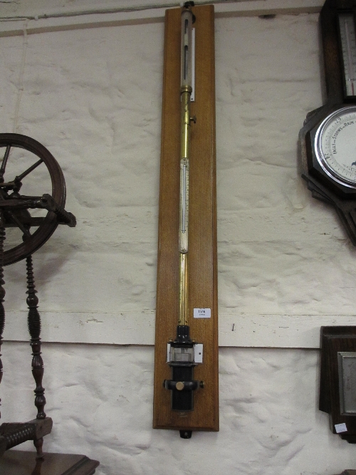 Negretti and Zambra brass and black Japanned marine stick barometer on oak back board