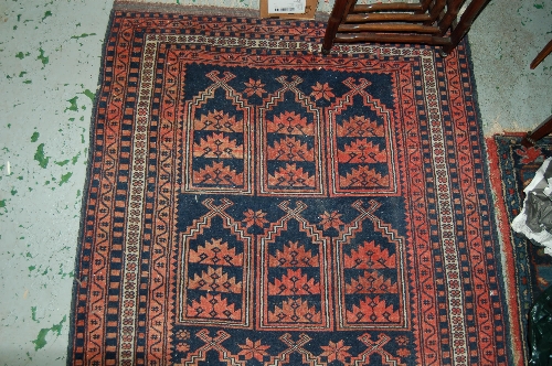 Belouch rug with stylised design in shades of red and blue