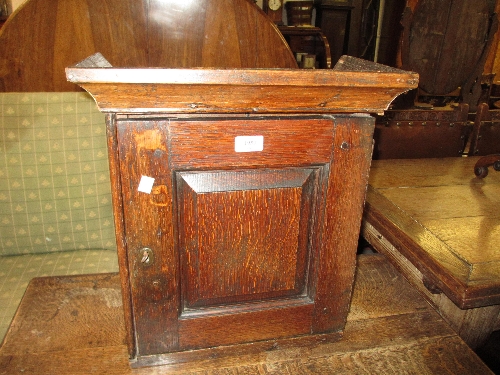 Early 18th Century oak spice cupboard with a moulded cornice above a fielded panel door enclosing