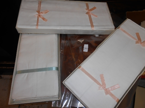 Three boxes containing a quantity of unused linen sheets