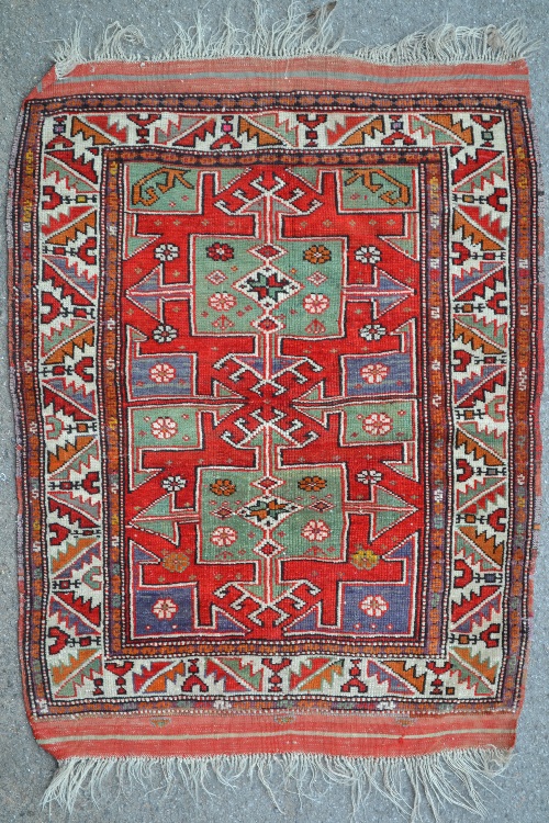 Small Kazak rug with twin medallion design on a red ground with borders