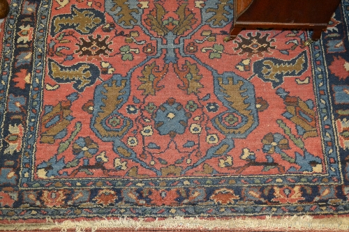 Small Hamadan rug with stylised floral design on pink ground with borders