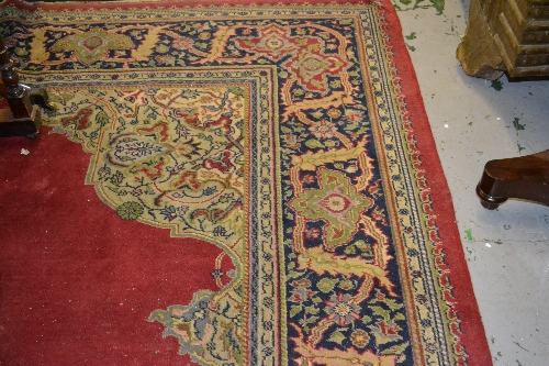 Persian pattern carpet with centre medallion and multiple borders on a dark red ground