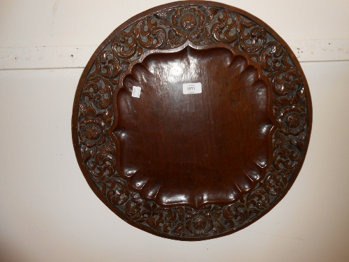 Carved circular hardwood plaque, the border carved with stylised decoration