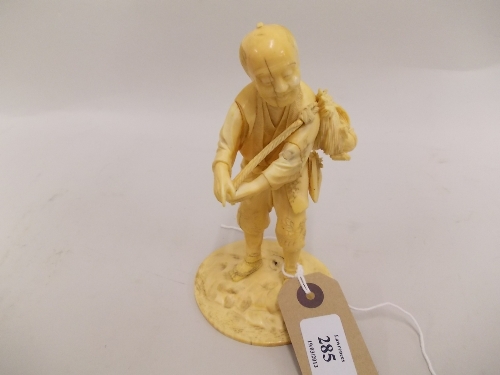 Small 19th Century Japanese carved ivory figure of a tradesman carrying a small bag over his