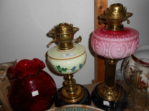 Two oil lamps and a large ruby glass shade