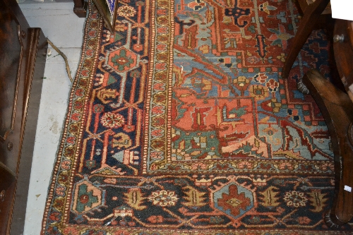 Heriz carpet with medallion and all-over stylised floral design on a blue and terracotta ground with