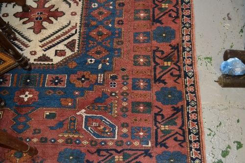 Anatolian carpet having geometric medallion design with borders on red and blue ground, 6ft x 6ft