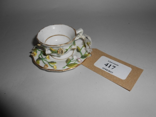 Miniature cup and saucer with encrusted floral decoration, printed mark in puce