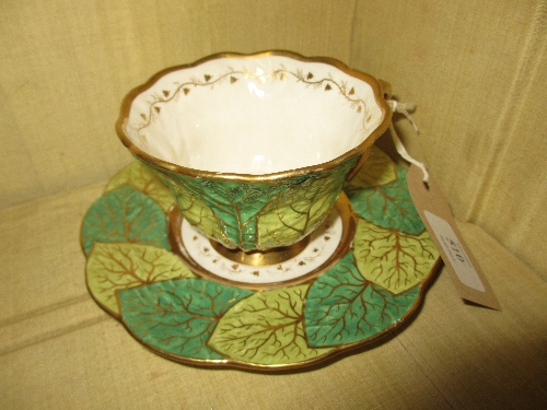Cabinet cup and saucer of primrose leaf design decorated in pale and dark green with gilding,