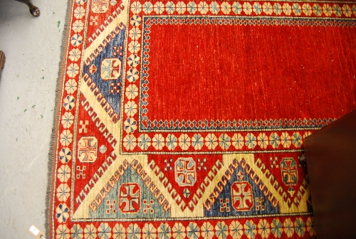 Afghan Kazak pattern rug with geometric decoration on a red ground