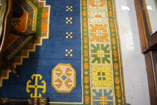 Turkish Persian pattern carpet with centre geometric medallion and multiple borders on a blue