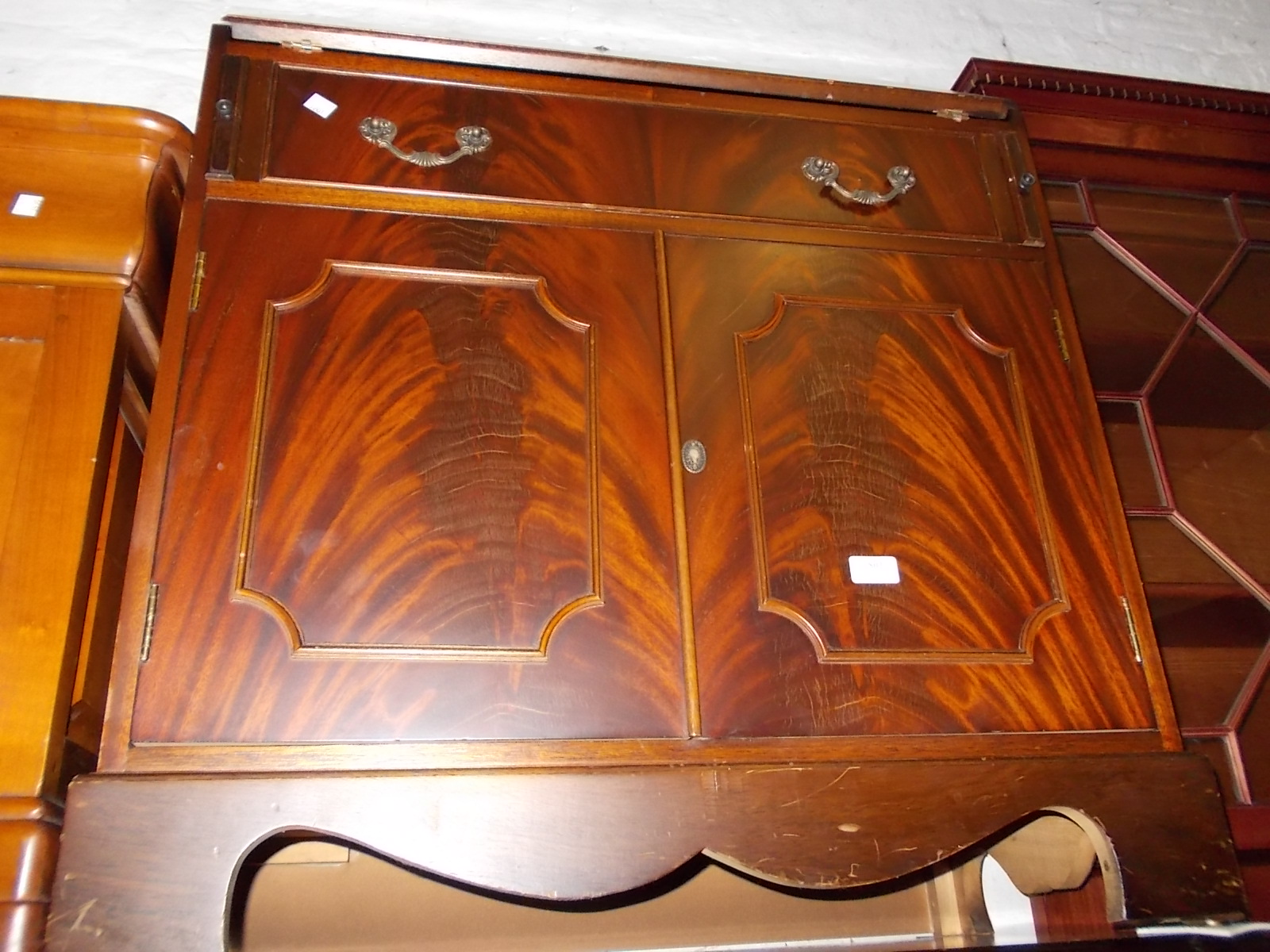 Reproduction mahogany bureau with fall front above a single drawer and pair of panel doors on