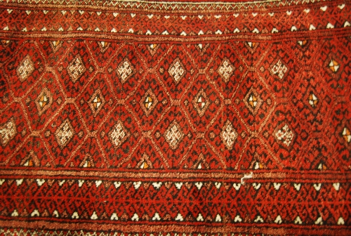 Two small Afghan Belouch rugs with geometric designs on dark ground and another small woven mat