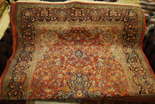 Kashan rug decorated with a centre panel and all-over floral surround with multiple border on a