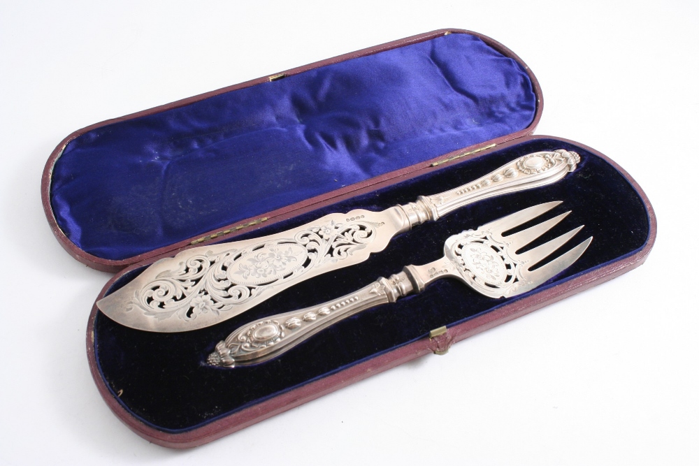 A VICTORIAN CASED, FISH SERVING KNIFE & FORK with pierced & engraved blade & tines, ornate handles