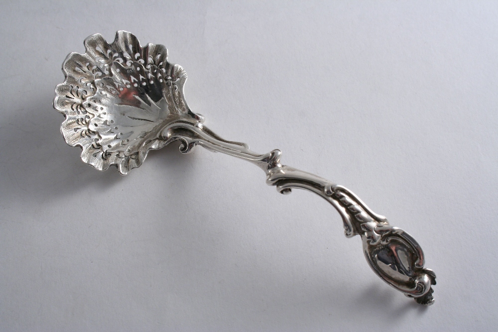 A VICTORIAN CAST SUGAR SIFTER LADLE with a part-matted, shell bowl & a scrollwork stem with vacant