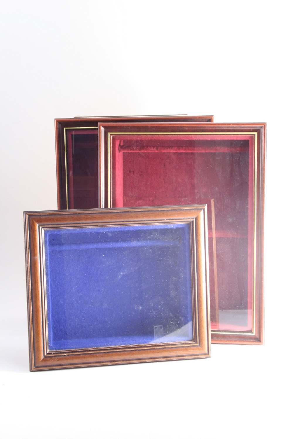 THREE GLAZED WALL-MOUNTING CASES for displaying sugar tongs; the largest ones 16.75" (42 cms)