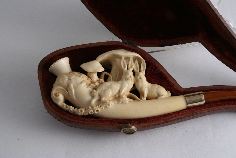 A MEERSCHAUM PIPE the bowl carved with hares and fungi, 9.5 cms with amber mouthpiece and case