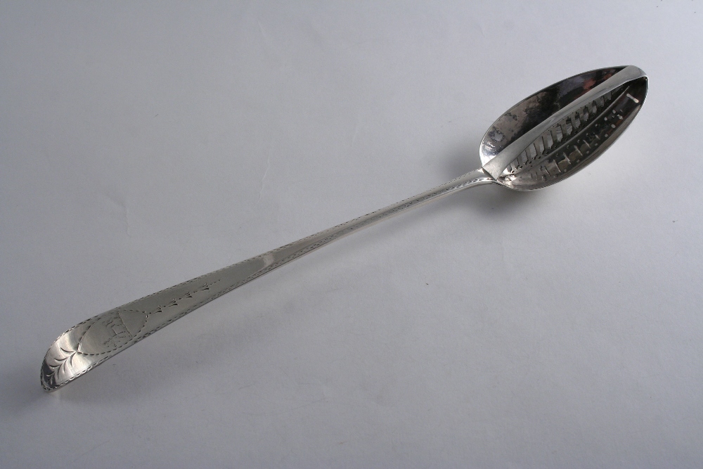 A GEORGE III IRISH BRIGHT-CUT DIVIDER SPOON crested, by J. Shields, Dublin 1786; 12.3" (31.5 cms)