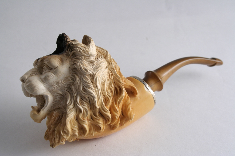 A MEERSCHAUM PIPE the bowl carved as a lion`s head, 9 cms, with mouthpiece and case