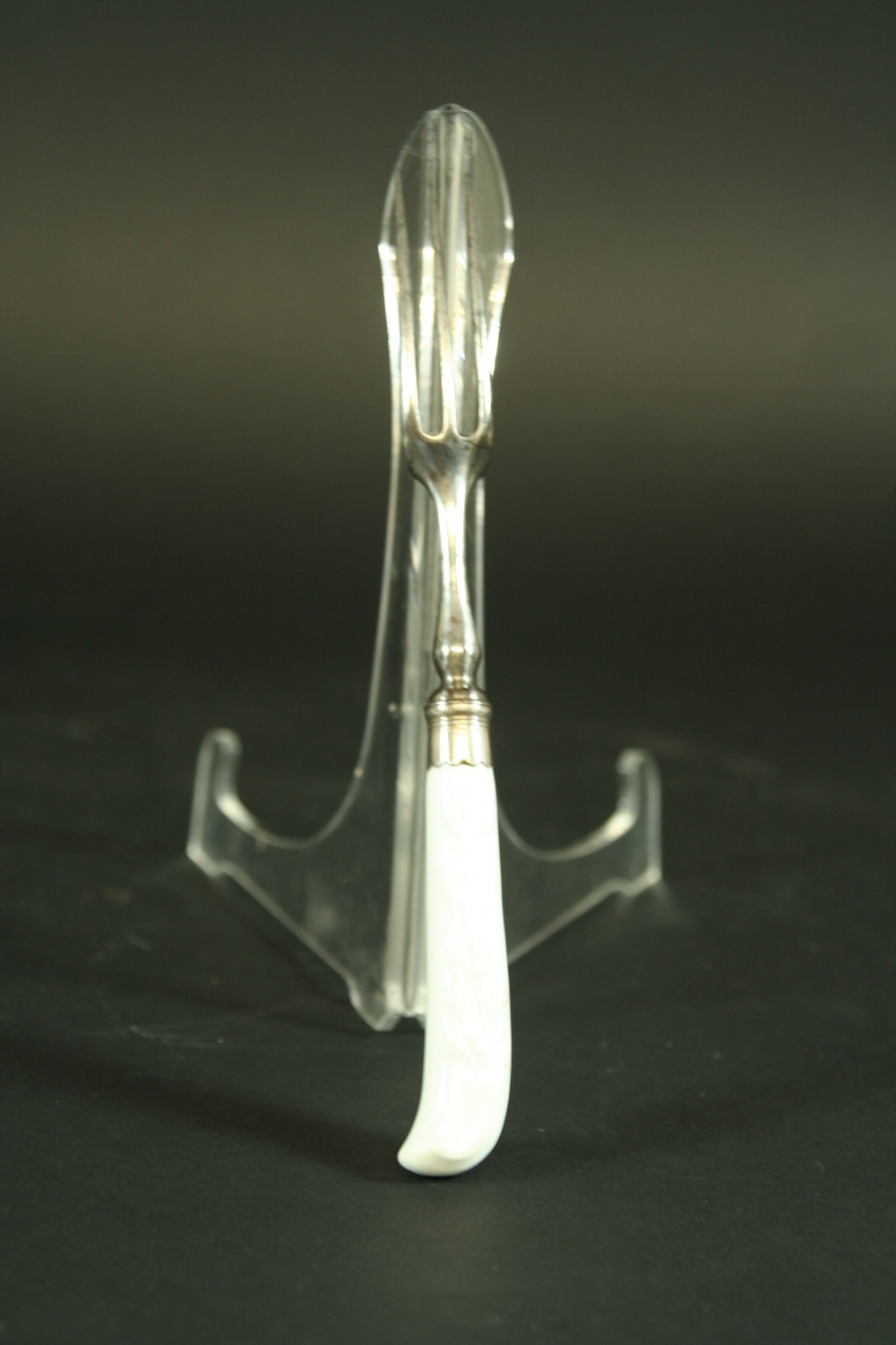 AN 18TH CENTURY FORK with pistol grip handle, moulded in low relief with foliate decoration