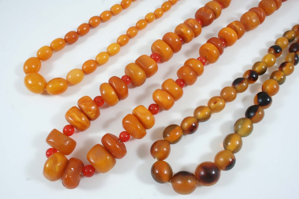 A SINGLE ROW AMBER BEAD NECKLACE formed with graduated oval-shaped amber beads, 45.5cm. long., 20