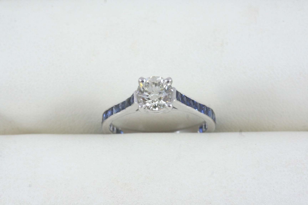 A DIAMOND AND SAPPHIRE RING set with a brilliant-cut diamond weighing approximately 0.90 carats,