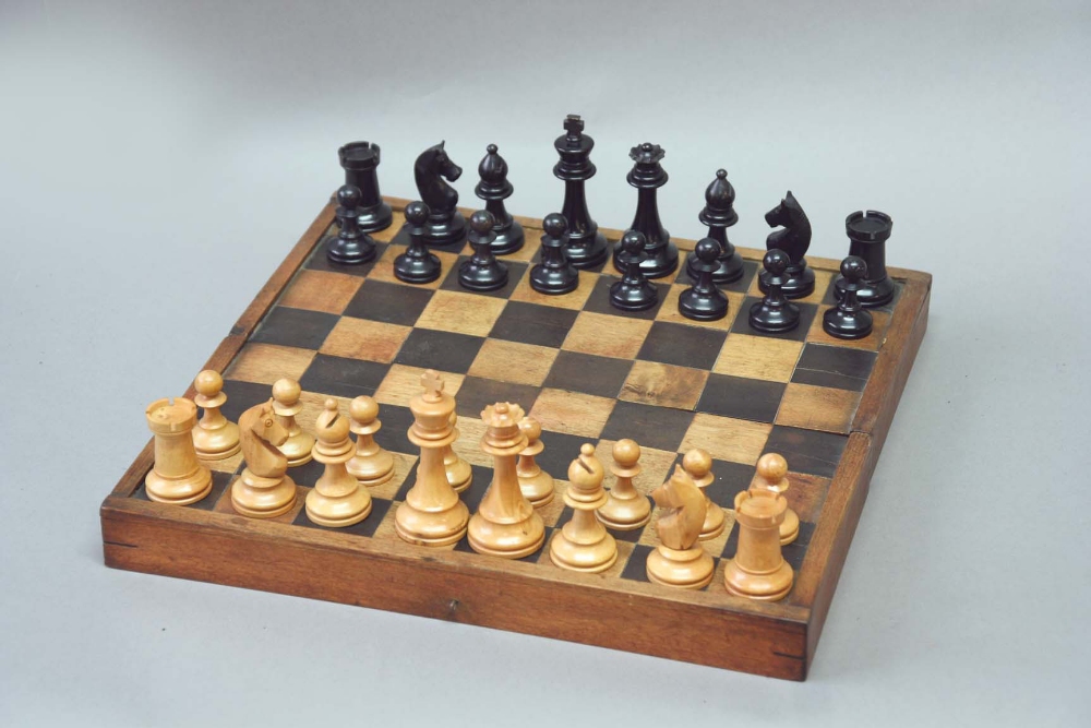 A STAUNTON TYPE EBONISED AND BOXWOOD CHESS SET King 3ins. (7.5cms.) high, together with a folding