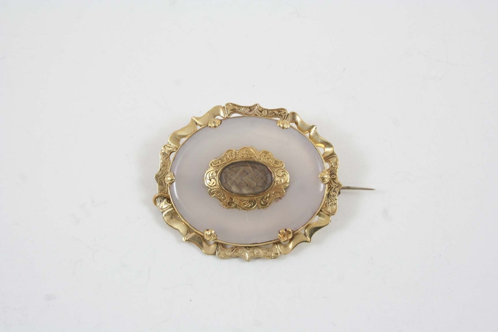 A VICTORIAN CHALCEDONY AND GOLD MOURNING BROOCH the oval chalcedony is centred with an oval