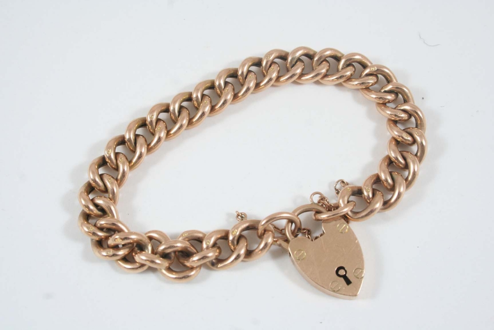 A 9CT. GOLD CURB LINK BRACELET with padlock clasp, 17 grams.