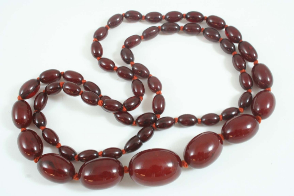 A SINGLE ROW GRADUATED AMBROID BEAD NECKLACE formed with oval-shaped beads, 88cm. long, 64 grams.