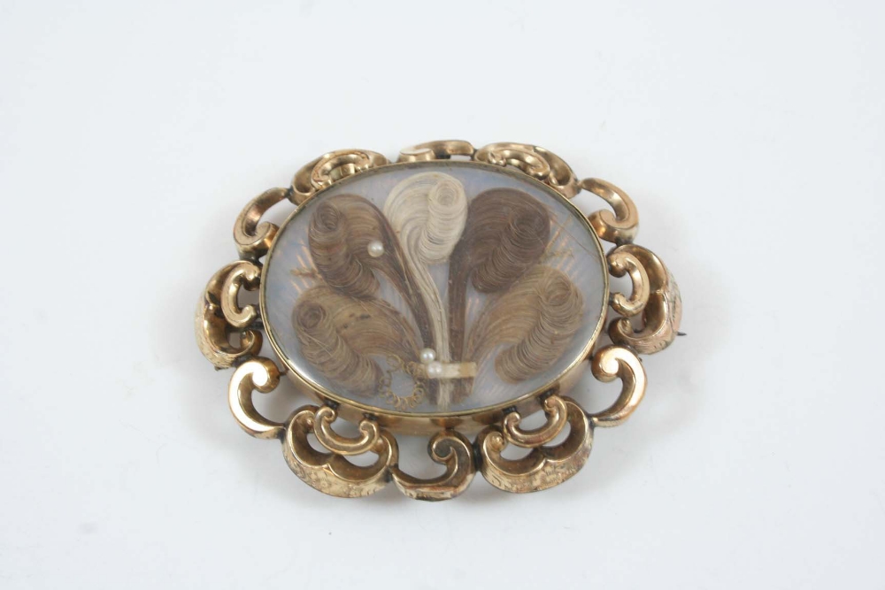 A VICTORIAN GOLD MOURNING BROOCH the oval centre section containing hair with pearl decoration,