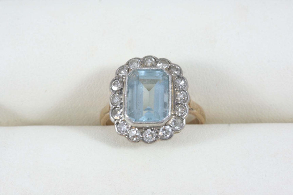 AN AQUAMARINE AND DIAMOND CLUSTER RING the octagonal-shaped aquamarine is set within a surround of