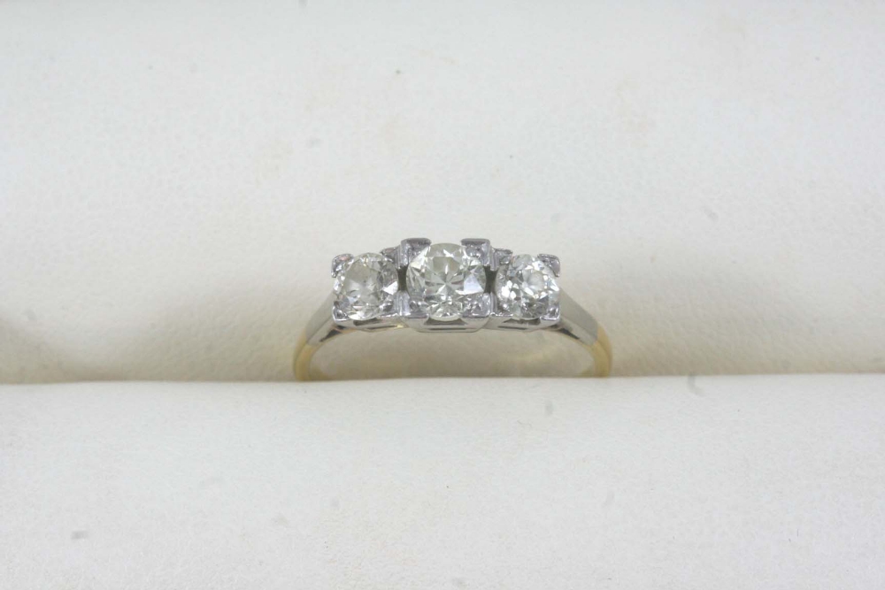 A DIAMOND THREE STONE RING set with three old brilliant-cut diamonds in square 18ct. gold