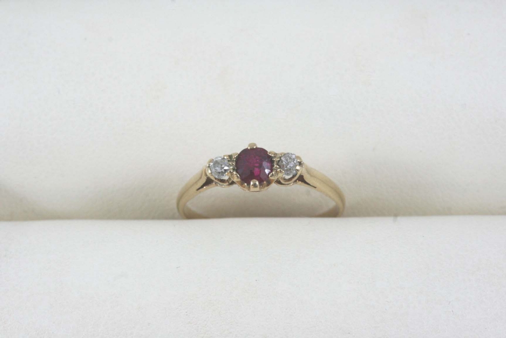 A RUBY AND DIAMOND THREE STONE RING the circular-cut ruby is set with two circular-cut diamonds,