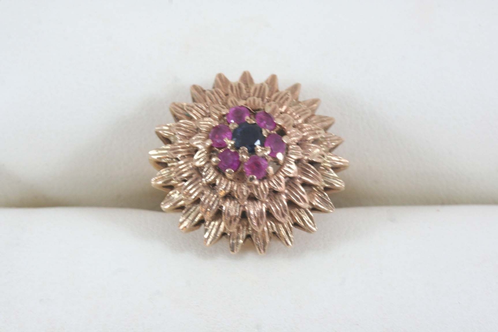 A GOLD AND GEM SET RING the gold flowerhead design set with a circular-cut sapphire and six