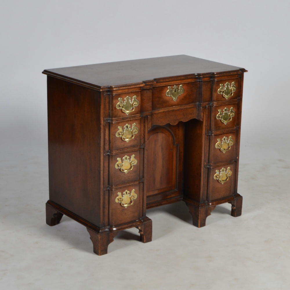 A George III mahogany knee hole desk, the shaped rectangular top with a moulded edge, above a long