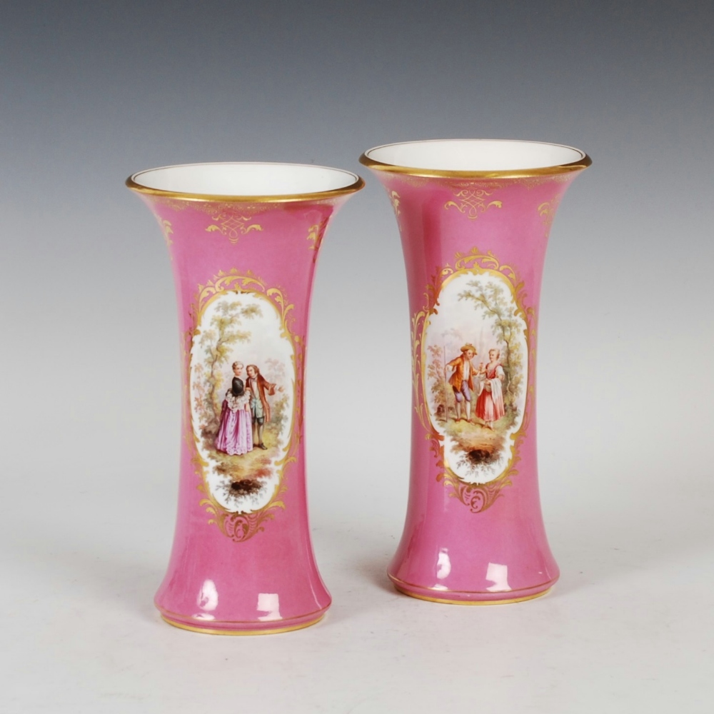 A pair of Meissen porcelain pink ground vases, decorated with oval shaped panels of courting figures