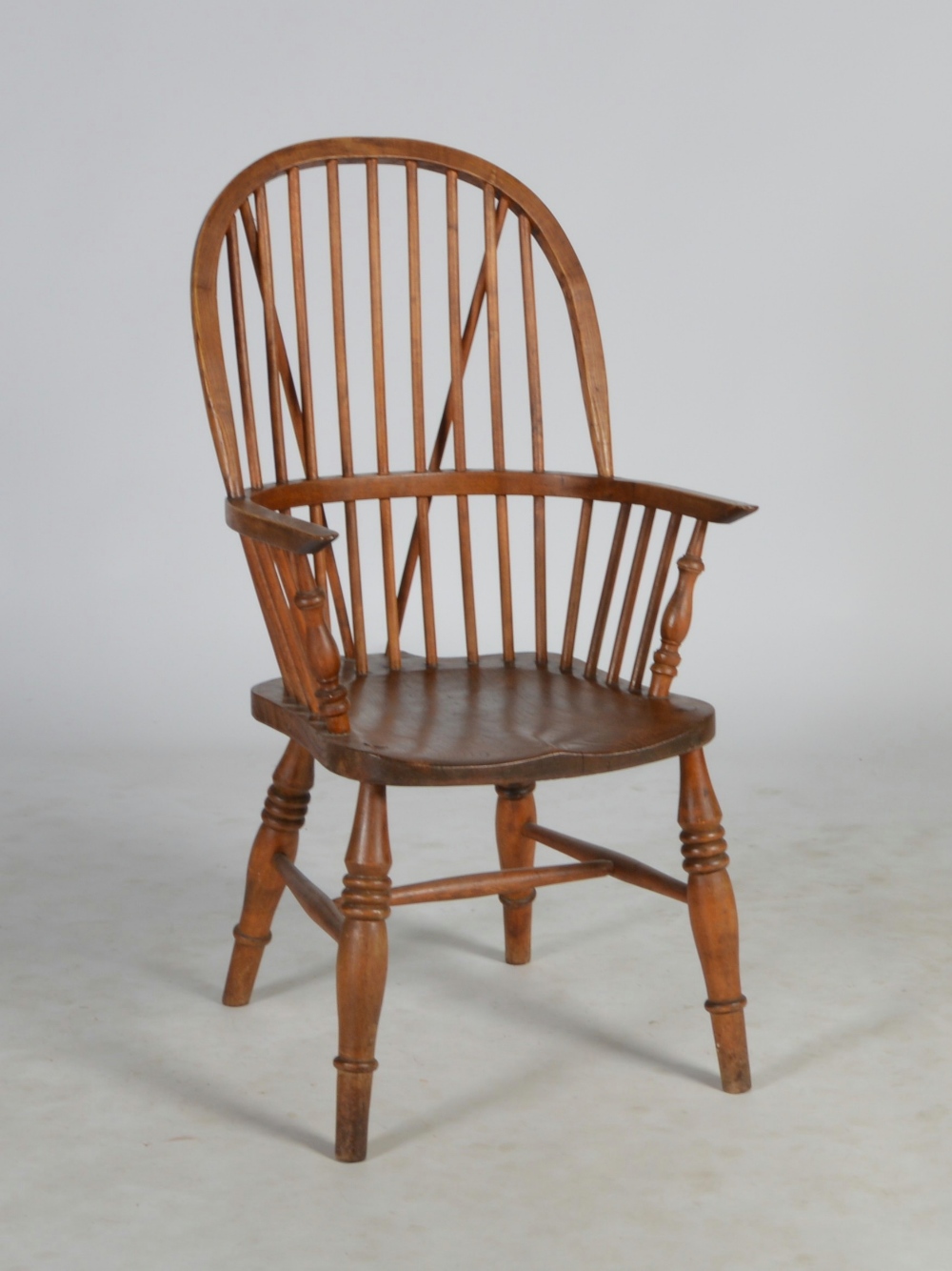 A 19th century elm and ash Windsor armchair, the arched back with a spindle filled gallery, the arms