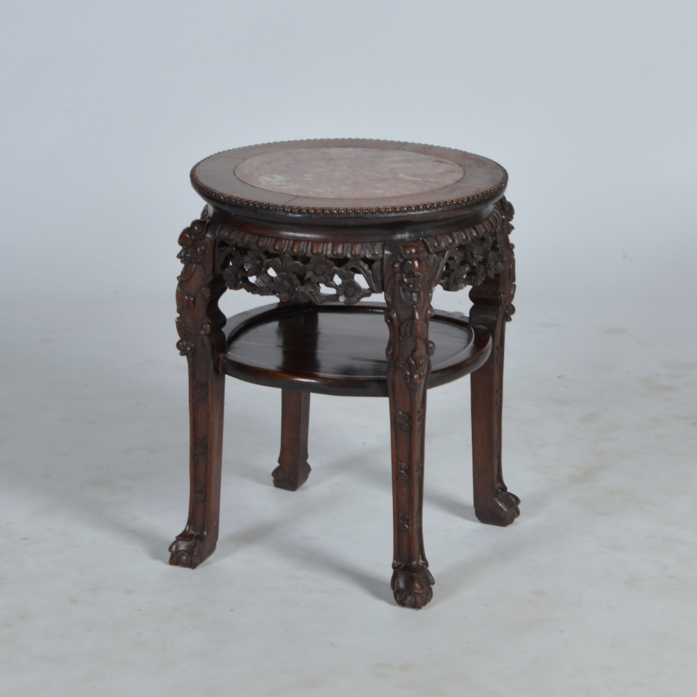 A Chinese dark wood and marble topped jardiniere stand, Qing Dynasty, the circular top with red