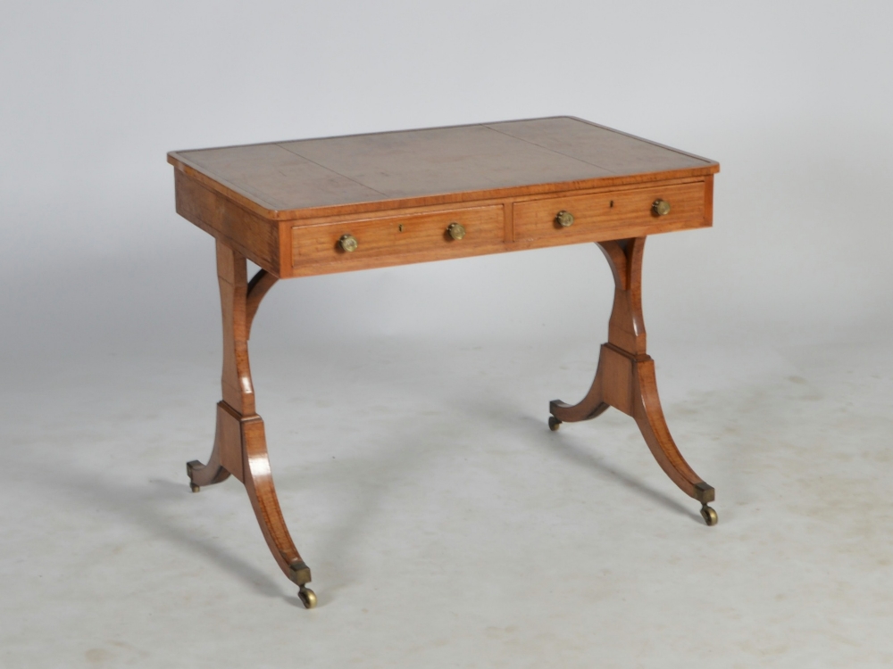 A Regency rosewood and boxwood lined library table, the rectangular top with gilt tooled leather