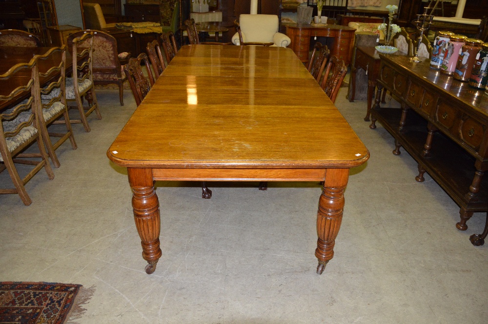 A Victorian oak extending dining table, the rounded rectangular top enclosing four additional