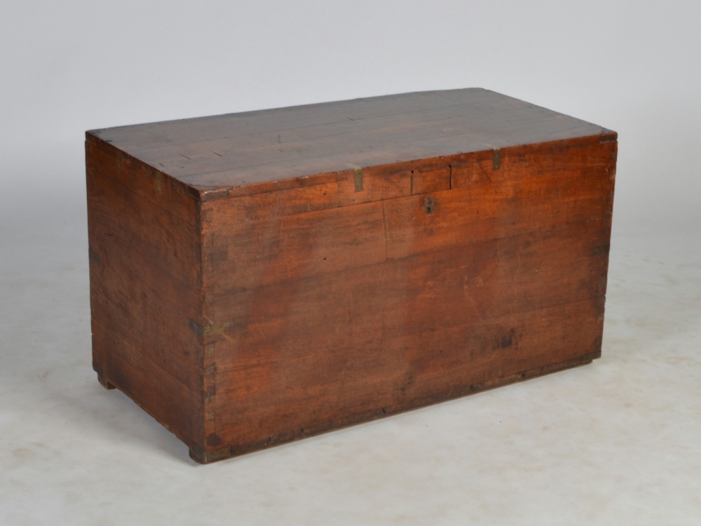 A 19th century teak and brass bound chest, the hinged rectangular top opening to a plain interior,